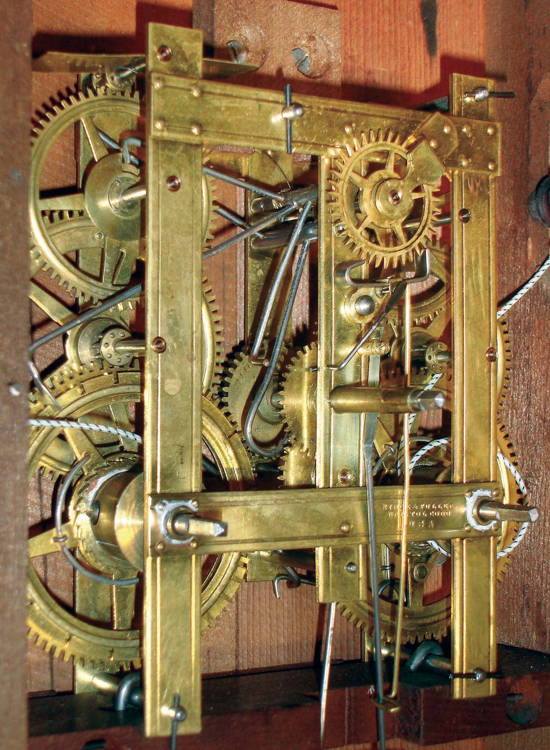The brass wagon-spring movement inside a Birge and Fuller clock, showing the gear train and leaf spring mechanism